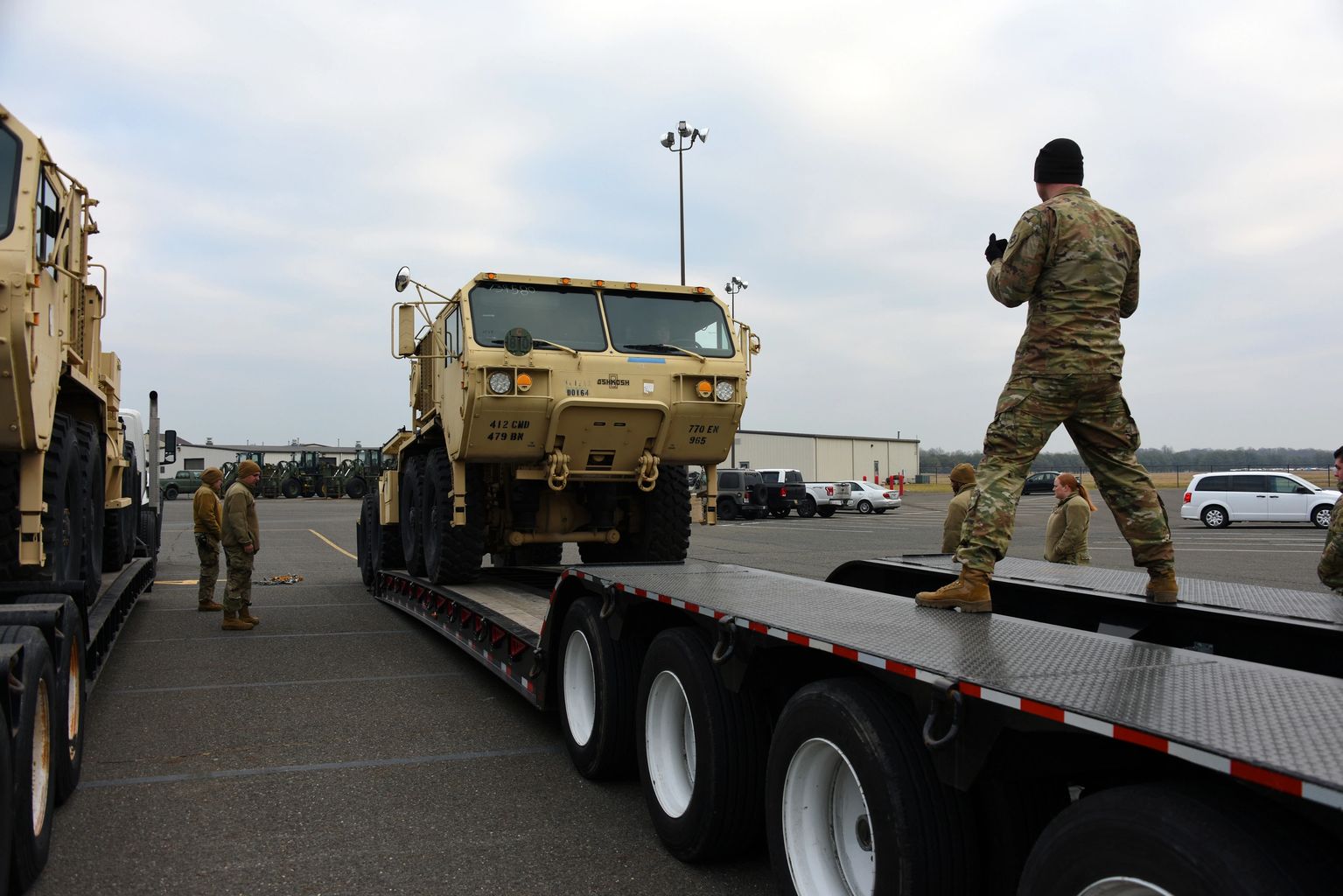 Military vehicle being loaded onto a flatbed trailer